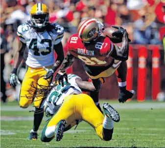  ?? Photos by Carlos Avila Gonzalez / The Chronicle ?? Wide receiver Anquan Boldin is upended by Green Bay safety Jerron McMillian in the first quarter. Boldin caught 13 passes for 208 yards and a touchdown in his debut with the 49ers.