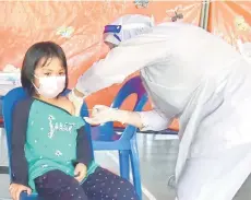  ?? — Bernama photo ?? A child getting her Covid-19 vaccine at the Sekolah Kebangsaan Sg Lada vaccinatio­n centre in Labuan on Friday.