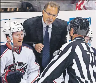  ?? CP PHOTO ?? Columbus Blue Jackets head coach John Tortorella, centre, talks with linesman Brad Kovachik (71) with Scott Hartnell, left, listening in this Oct. 8 file photo.