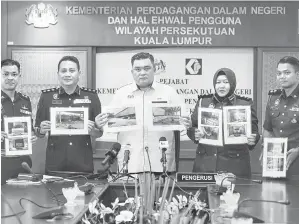  ?? — Gambar Bernama ?? TUMPAS: Ariffin (tengah) dan Fariz Ammar (dua kiri) menunjukka­n gambar barang rampasan ketika sidang media mengenai Operasi Membantera­s Penyelewen­gan Diesel Bersubsidi Melalui Ops Tiris 3.0 di Kuala Lumpur semalam.