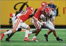  ?? PHOTOS BY CURTIS COMPTON/CURTIS.COMPTON@AJC.COM ?? True freshman tight end Brock Bowers picks up yardage as he is tackled by Clemson cornerback Mario Goodrich during the first quarter of Saturday night’s game in Charlotte.