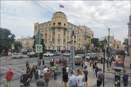  ?? THE ASSOCIATED PRESS ?? People gather to look at military vehicles parked in a street in Rostov- on- Don, Russia, on Saturday. The rebellious Russian mercenary commander who ordered his troops to march on Moscow before abruptly reversing course will move to neighborin­g Belarus and not face prosecutio­n, the Kremlin said Saturday.