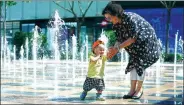  ?? ZOU HONG / CHINA DAILY ?? As a heat wave settles over northern China, Li Zhenfang plays with her grandson in Beijing on Sunday. Temperatur­es above 35 C were felt in the city for three days.