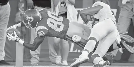  ?? Photograph­s by Wally Skalij Los Angeles Times ?? DEONTAY BURNETT DIVES for the end zone to score his first of two touchdowns Saturday. It was his third big game in a row.