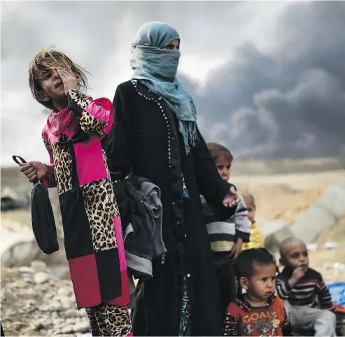  ??  ?? BULENT KILIC / AFP / GETTY IMAGES Families displaced by conflict in Mosul gather near Qayyarah Monday. Iraqi forces are attempting to retake the northern city from ISIL.