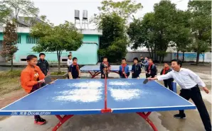  ?? ?? Huang Xinglai, a 61-year-old retired teacher, plays ping pong with students at a primary school in Huping Township, Fuzhou City in Jiangxi Province, on 28 October 2019