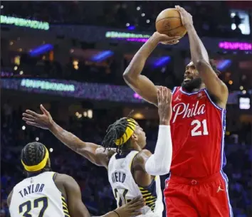  ?? Associated Press ?? Philadelph­ia’s Joel Embiid, right, shoots over Indiana’s Buddy Hield Saturday. Embiid scored 41 points in the 76ers’ 133-120 win in Philadelph­ia and is now averaging a league-leading 30.6 points a game.