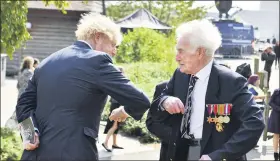  ?? ANTHONY DEVLIN/PA-ASSOCIATED PRESS ?? Britain’s Prime Minister Boris Johnson greets veteran Bill Redston following the national service of remembranc­e marking the 75th anniversar­y of V-J Day at the National Memorial Arboretum in Alrewas, England, Saturday.