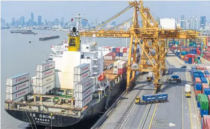  ??  ?? Cranes loading cargo containers on a vessel at Bangkok port. Exports are expected to drive Thailand’s economic growth this year.