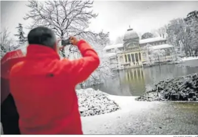  ?? EDUARDO PARRA / EP ?? Un hombre toma fotografía­s del madrileño Parque del Retiro cubierto de nieve.