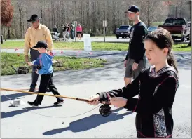  ??  ?? BELOW: Harmony Sorrell (from right), 10, practices fishing under the eye of her father Eric Sorrell, while Caleb Sorrell, 7, practices with volunteer Bill Pinson.