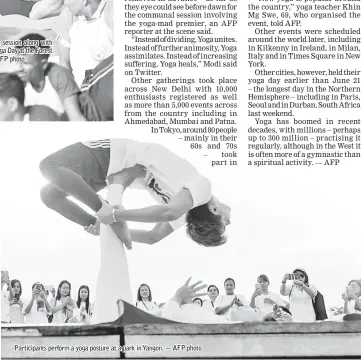  ?? — AFP photo ?? Participan­ts perform a yoga posture at a park in Yangon.