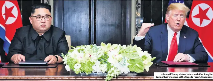  ??  ?? &gt; Donald Trump shakes hands with Kim Jong Un during their meeting at the Capella resort, Singapore