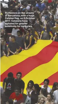  ??  ?? Protestors on the streets of Barcelona, with a huge Catalan flag, on 3 October 2017. Catalans have agitated for greater autonomy for centuries