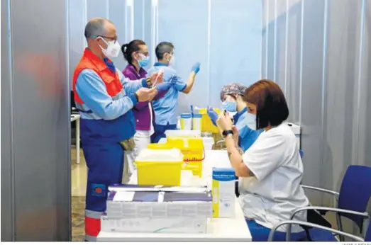  ?? JAVIER ALBIÑANA ?? Sanitarios preparando las dosis de la vacuna contra el Covid en un centro de inmunizaci­ón de Málaga.