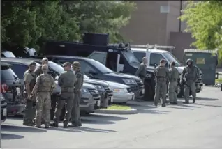  ?? JERRY JACKSON/THE BALTIMORE SUN VIA AP ?? Tactical police stage in a Safeway parking lot on Belair Road near Chapel Road in response to the death of a Baltimore County police officer in Perry Hall, Md., on Monday. Rifle-toting police swarmed into the Baltimore suburb where a female officer was...