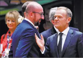  ?? Geert Vanden Wijngaert ?? The Associated Press European Council President Donald Tusk, right, speaks with Belgian Prime Minister Charles Michel during a roundtable meeting Thursday at an EU summit in Brussels.