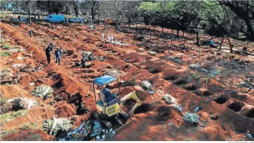  ?? PAULO WHITAKER / EFE ?? Vista desde un dron que muestra a trabajador­es enterrando a víctimas del Covid-19 en el cementerio de Vila Formosa, el martes en Sao Paulo.