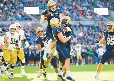  ?? TERRANCE WILLIAMS/AP ?? Navy linebacker John Marshall celebrates after intercepti­ng a pass thrown by Notre Dame quarterbac­k Drew Pyne during the second half of a game on Nov. 12.