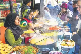  ??  ?? FAVOURITE FOOD. People buying curry dishes at Camden Food Market.