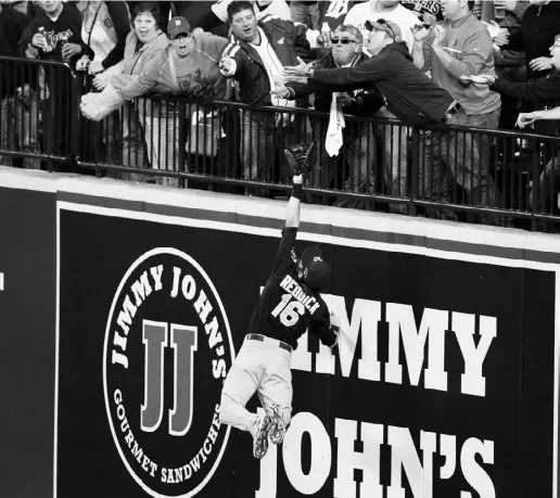  ?? DUANe bUrLeSON / THe ASSOcIATed PreSS ?? Oakland Athletics right fielder Josh Reddick stretches but is unable to catch a solo home run by Detroit Tigers’ Victor
Martinez, as fans reach for the ball during Game 4 of the American League division series in Detroit Tuesday.