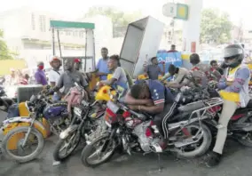  ??  ?? Moto-taxi drivers wait their turn to fill their tanks at a gas station in Port-au-prince, Tuesday, July 13, 2021, almost a week after President Jovenel Moïse was assassinat­ed in his home.