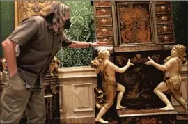  ?? Genaro Molina Los Angeles Times ?? FURNITURE in the collection, including the ornate 17th century Boulle Cabinet that lead preparator Michael Mitchell stands beside, was taken apart for cleaning.