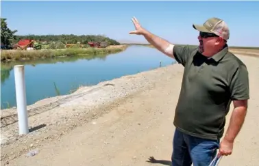  ?? AP PHOTO/ADAM BEAM ?? In July, Kevin Spesert, public affairs and real estate manager for the Sites Project Authority, points out the main canal of the Glenn Colusa Irrigation District near Sites, Calif.