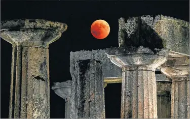  ?? FOTOS: AFP ?? ROJA. La ‘Luna de sangre’ sobre las ruinas del templo de Apolo en Corinto, Grecia.