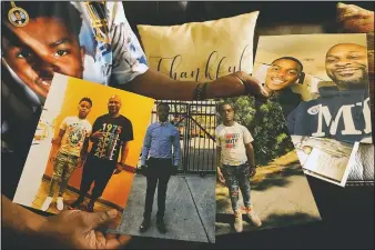  ??  ?? Kevin and Rontunda Moran hold family photos of their son Jaquan Anderson. Unbeknowns­t to his family, Jaquan had an enlarged heart that made him more susceptibl­e to the coronaviru­s.