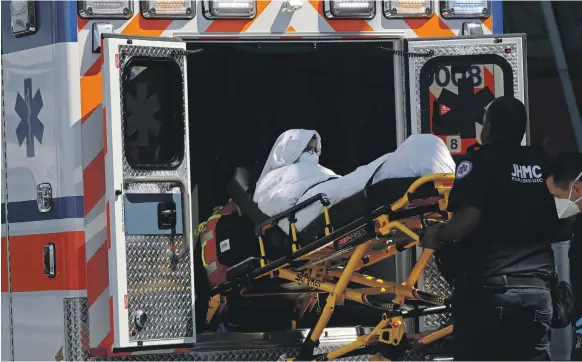  ?? EPA ?? A passenger from EK203 is carried away by paramedics at JFK Internatio­nal Airport. About 100 people from the flight said they felt ill