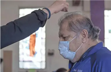  ?? PHOTOS BY NICK OZA/THE REPUBLIC ?? Parishione­rs wear masks during an Ash Wednesday Mass at St. Matthew’s Catholic Church in Phoenix amid the coronaviru­s pandemic. Parishione­rs also were asked to practice social distancing.