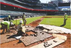  ?? DAVID GOLDMAN / THE ASSOCIATED PRESS ?? Constructi­on workers lay down a foundation for home plate at SunTrust Park earlier this month. The new stadium got a test run this past week with a team workout Thursday and an exhibition game Friday night.