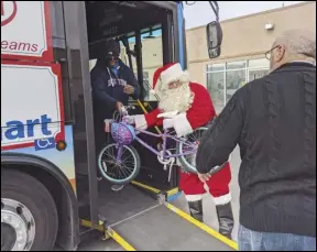  ?? JULIE DRAKE/Valley Press ?? Martin Tompkins, Antelope Valley Transit Authority’s senior director of Operations and Planning, wore a Santa suit to deliver toys collected during the AVTA’s annual Stuff-a-Bus toy drive.