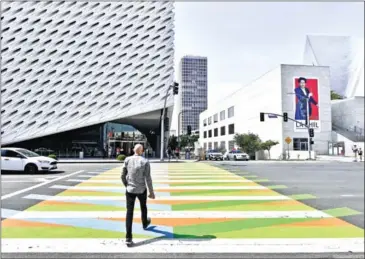  ?? FREDERIC J BROWN/AFP ?? A man crosses a pedestrian crossing painted by Venezuelan artist Carlos Cruz-Diez toward the Broad Museum in Los Angeles, California in September 2017.