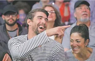  ?? JAE C. HONG/ASSOCIATED PRESS FILE PHOTO ?? Michael Phelps and his wife, Nicole Johnson, attend an NBA game in March. Phelps all but slammed the door on another return after leaving it ever-so slightly ajar in an interview with The Associated Press last month.