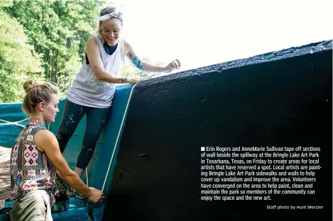  ?? Staff photo by Hunt Mercier ?? ■ Erin Rogers and AnneMarie Sullivan tape off sections of wall beside the spillway at the Bringle Lake Art Park in Texarkana, Texas, on Friday to create areas for local artists that have reserved a spot. Local artists are painting Bringle Lake Art Park sidewalks and walls to help cover up vandalism and improve the area. Volunteers have converged on the area to help paint, clean and maintain the park so members of the community can enjoy the space and the new art.