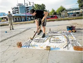  ?? PHOTO: DAVID JAMES/STUFF ?? Zakea Page is watched by his grandad as he creates an artwork with a hockey stick, a tennis ball and a bucket of Chinese ink.