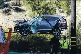  ?? ASSOCIATED PRESS FILE PHOTO ?? A crane is used to lift the SUV that Tiger Woods was driving when it crashed in the Rancho Palos Verdes suburb of Los Angeles. Woods suffered serious leg injuries.