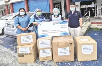  ??  ?? Maslihah (second left) hands over the mock cheque for the donation from BPHB to Reylene during the simple ceremony in Kuching.