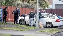  ?? ANDY JACKSON/ STUFF ?? Members of the Armed Offenders Squad debrief outside the Maui Pl, Spotswood, house after they cleared it yesterday morning.