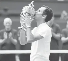  ??  ?? Wimbledon men’s singles champion Roger Federer kisses the Wimbledon trophy.