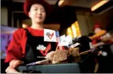  ?? PROVIDED TO CHINA DAILY ?? A hostess holds a tray of sliced US beef at an event to celebrate its reintroduc­tion to China in Beijing.