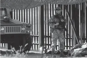  ?? ERIC GAY/AP ?? National Guardsmen stand watch Sunday at a gate along a fence near the Internatio­nal Bridge where thousands of Haitian migrants have created a makeshift camp in Del Rio, Texas.