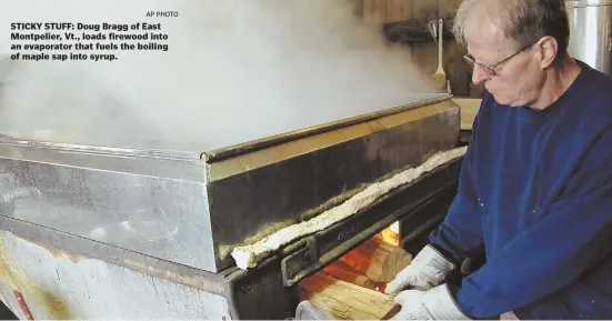  ?? AP PHOTO ?? STICKY STUFF: Doug Bragg of East Montpelier, Vt., loads firewood into an evaporator that fuels the boiling of maple sap into syrup.