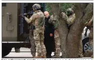  ?? (AP/The Dallas Morning News/Elias Valverde) ?? Law enforcemen­t agents escort a hostage out of a synagogue in Colleyvill­e, Texas, on Saturday, after a standoff inside the temple.