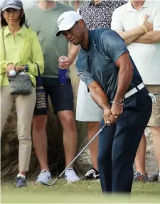  ?? PHOTO AFP ?? Tiger Woods a connu un début de journée difficile, hier. Au troisième trou, où il a réalisé un boguey, on le voit tenter un coup d’approche.