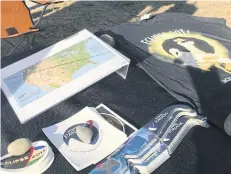  ??  ?? BELOW Eclipse sunglasses, T-shirt, map of the moon’s shadow during the August 21, 2017 eclipse, and stickers are seen at a table run by Wyoming Stargazing.