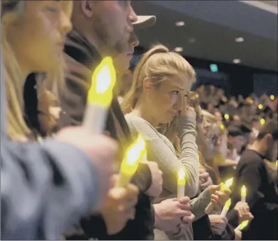  ??  ?? People gather to pray for the victims of the mass shooting during a candleligh­t vigil in Thousand Oaks, California.