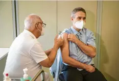  ?? Foto: Oliver Dietze, dpa ?? Hier gibt ein Arzt einem anderen Arzt eine Spritze mit dem Impfstoff gegen das Co‰ ronavirus.